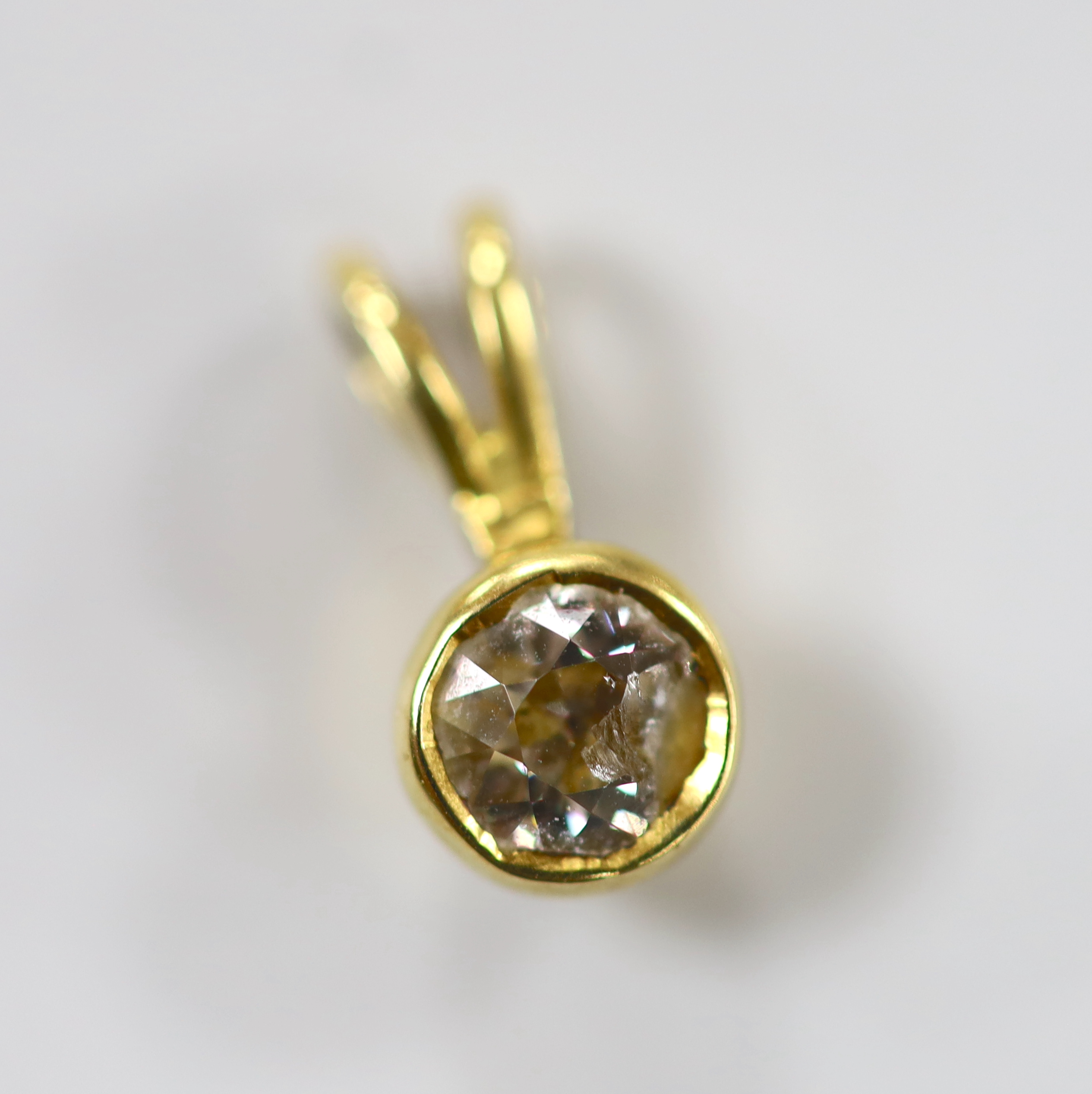 A yellow metal and solitaire diamond set pendant, 11mm, gross weight 1.3 grams (stone chipped).